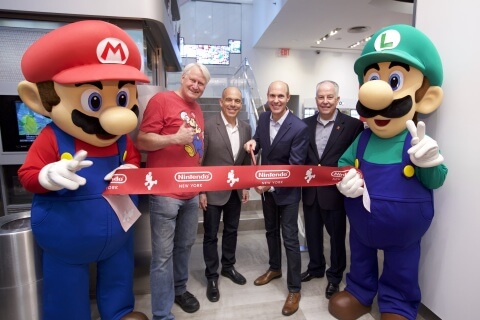 In this photo provided by Nintendo of America, Mario and Luigi unveil the remodeled Nintendo NY store during a ribbon-cutting ceremony on Feb. 19, 2016. Joining the Super Mario Bros. (left to right) are Charles Martinet, the voice of Mario, and Nintendo of America executives Doug Bowser, Vice President of Sales; Scott Moffitt, Executive Vice President of Sales & Marketing; and Rick Lessley, Vice President of the Supply Chain Group.​