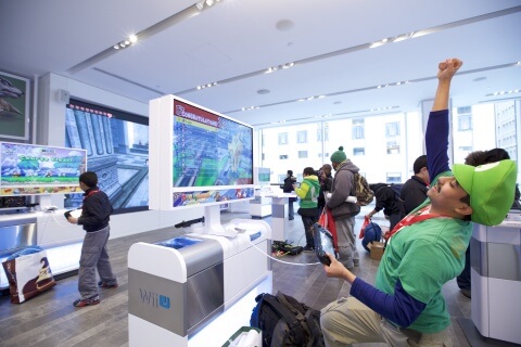 In this photo provided by Nintendo of America, Rinaldy G. of New York plays Mario Kart 8 using the Nintendo NY store’s upgraded Wii U demo units at the store's reopening on Feb. 19, 2016.