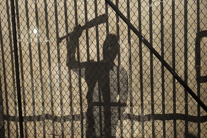 A silhouette of Negan at the gates of Alexandria