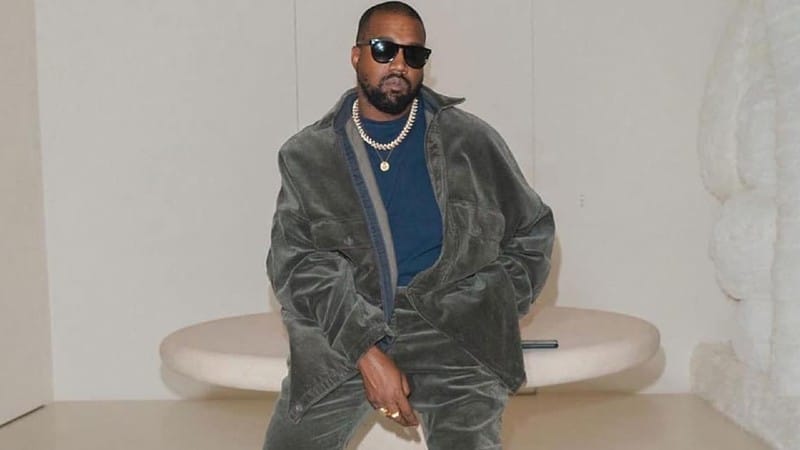 Kanye West poses in grey jacket, matching pants and sunshade