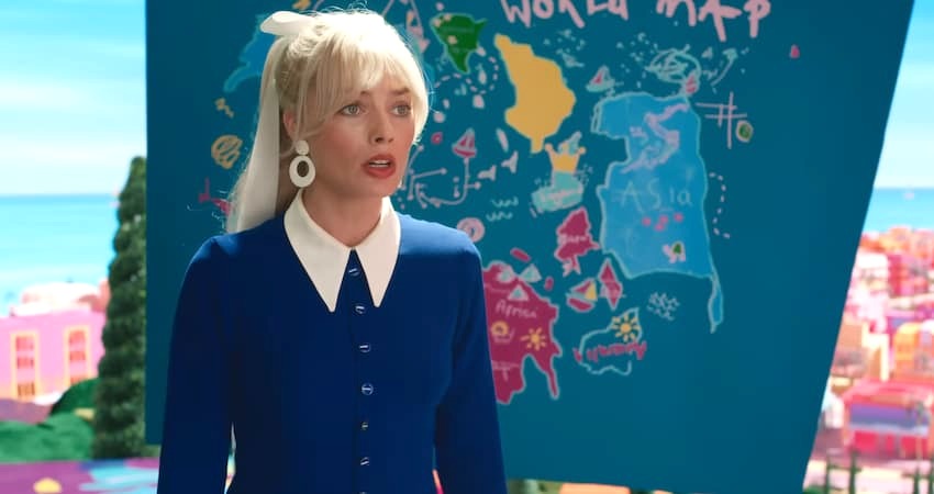 Margot Robbie as Barbie standing in front of a map in Barbie.