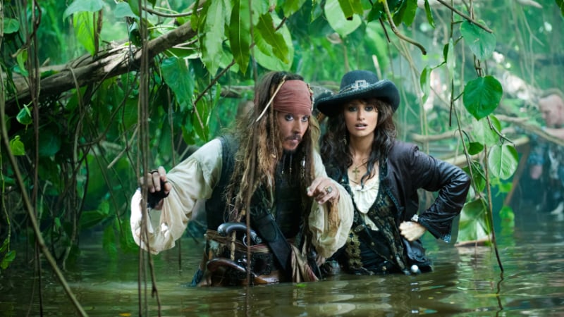Jack Sparrow and Angelica wade through a swamp in Pirates of the Caribbean: On Stranger Tides