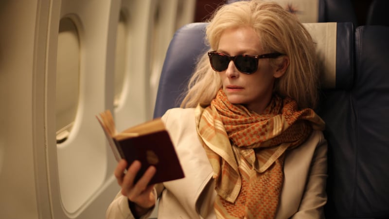 Tilda Swinton reading a book in Only Lovers Left Alive, wearing an outfit that would make a great Dead by Daylight cosmetic.
