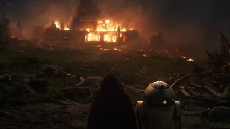 Luke Skywalker and R2-D2 looking at the burning Jedi Temple in The Last Jedi