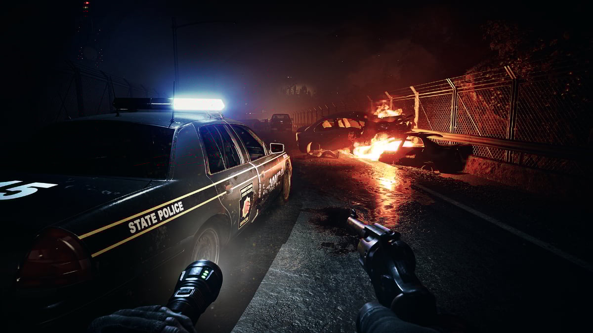 A fire burns behind a cop car in No More Room in Hell 2