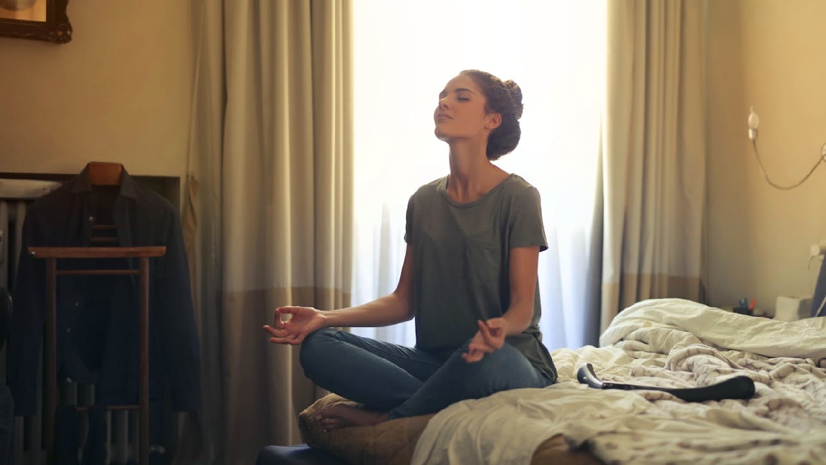 a woman meditating in her bedroom
