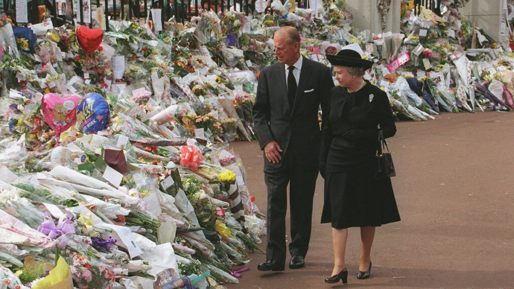 Queen Elizabeth and Prince Philip walk past millions of tribute items to Princess Diana after her death. 