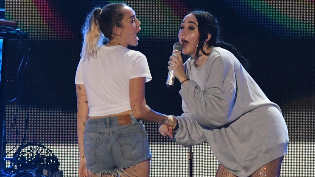 Miley Cyrus performs with her sister Noah Cyrus live onstage.