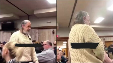 A man with a white beard wearing a light yellow sweater confronts Rep. Sean Casten