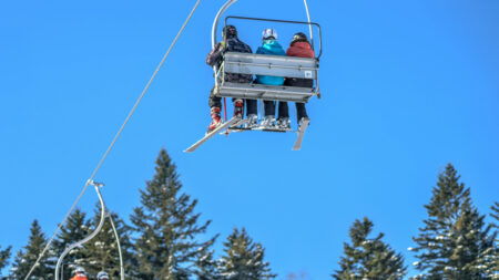 Snow Day Might Cost One Colorado Man $100k After Ski Collision Lawsuit: ‘Hire the Lawyer’ Skiers on a mountain lift with trees below them