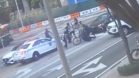 Miami Police Officer Chills in Her Cruiser While a Victim is Beaten By Local Cyclists a victim is beaten by cyclists in miami florida, while cop does nothing