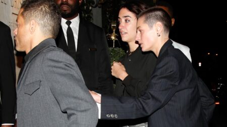 Rami Malek and Emma Corrin holding hands