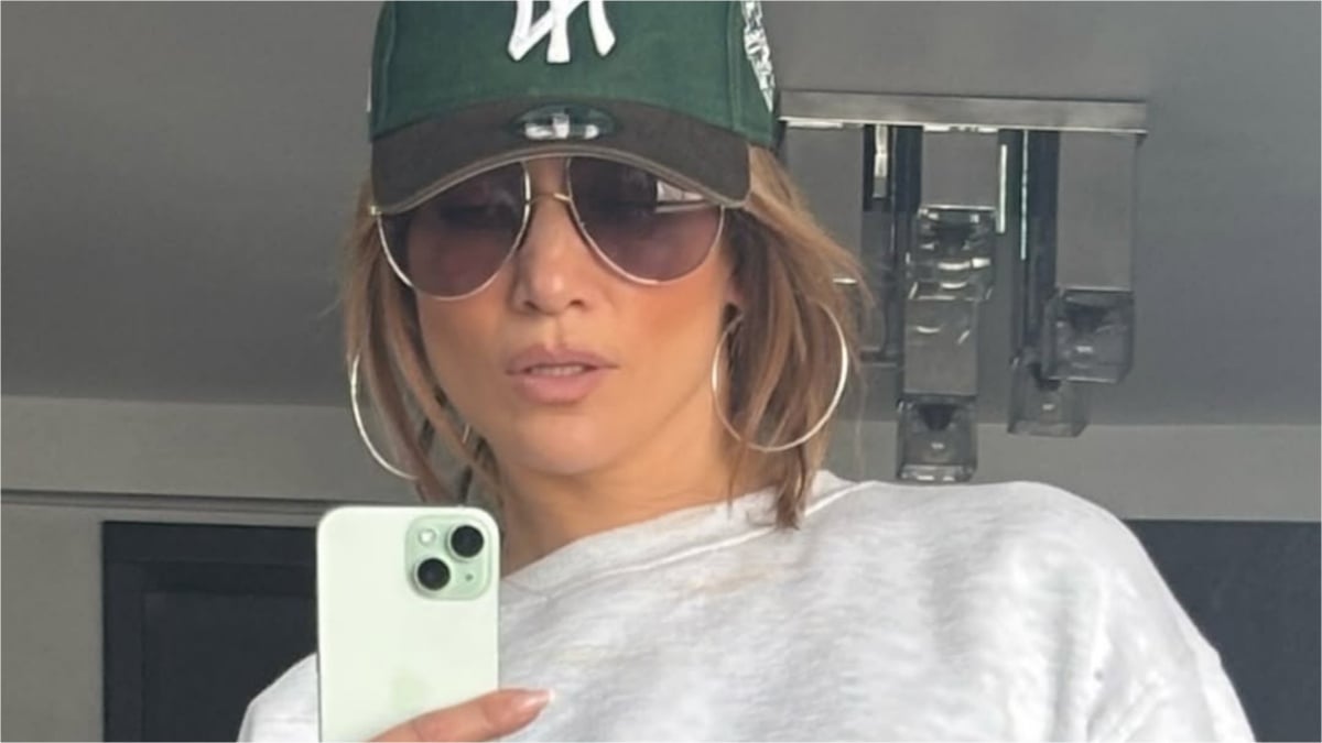 Jennifer Lopez takes a selfie in hat and sunglasses.