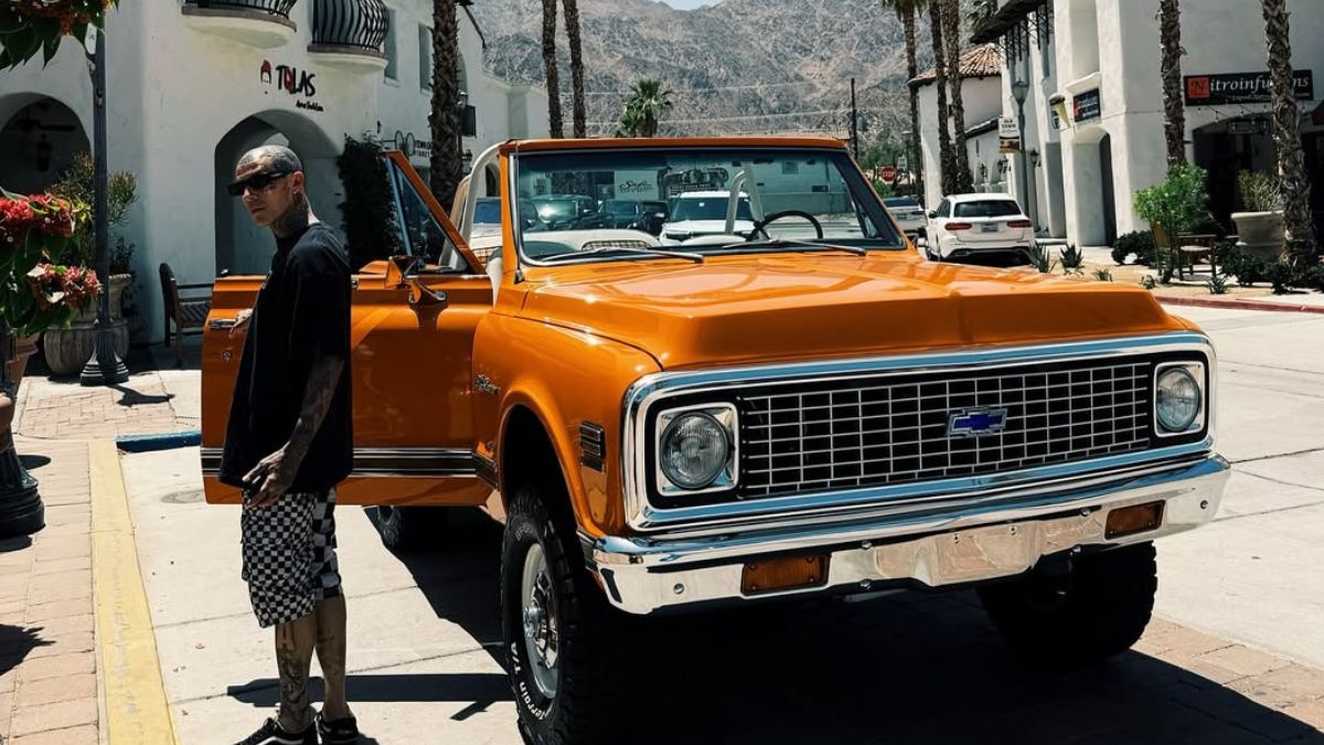 Travis Barker in front of a car