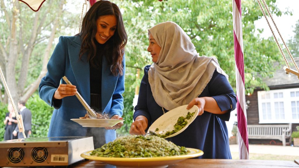 Meghan Markle interacting with locals during a royal engagement. 