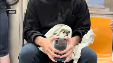 A man filming a woman on the NYC subway