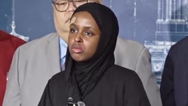 Nasra Ahmed speaks at the Minnesota State Capitol with bandages after an ICE arrest.
