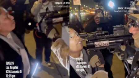ICE agent aiming a grenade launcher inches from a protester’s face during a tense standoff in California.
