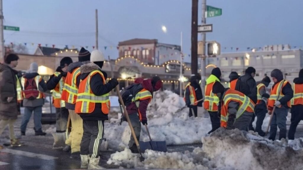 Group of city workers clearing a pile of snow on a New York street after a blizzard.