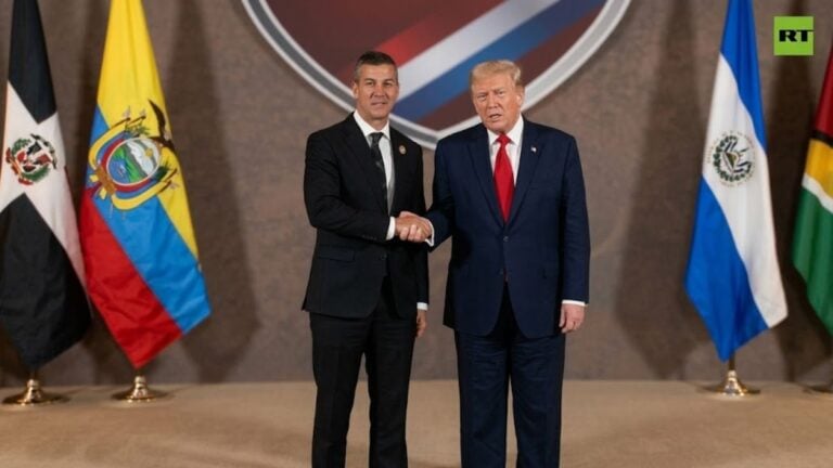 President Trump attempting his tug-of-war power handshake with Paraguay's President Santiago Peña at the Shield of the Americas Summit at Trump National Doral in Miami, Florida.