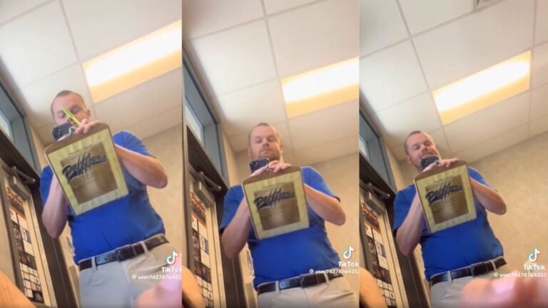 California Corcoran High School teacher Casey Snyder walking through a classroom appearing to secretly record students from above a cardboard.