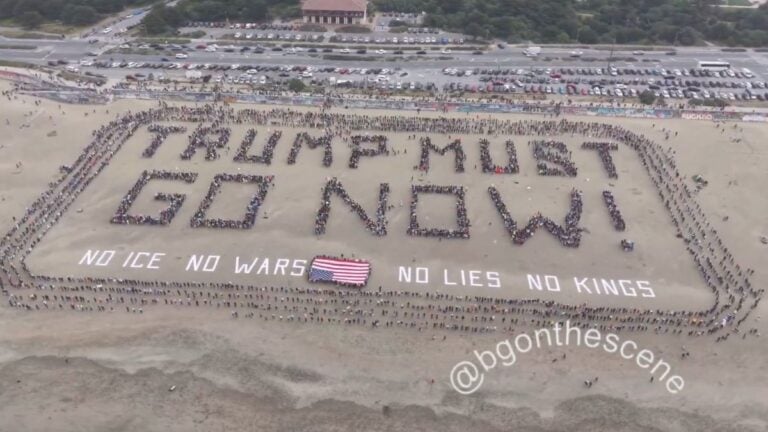 Aerial drone footage of hundreds of protesters forming a 600-foot human banner spelling Trump Must Go Now on San Francisco Ocean Beach California during No Kings Day on March 28 2026