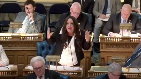 Republican Assemblywoman Dawn Fantasia speaking at a legislative podium during a floor debate on immigration legislation.