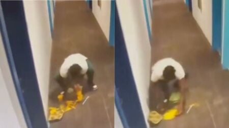 Apartment building hallway surveillance footage reportedly from Seattle, Washington captures a DoorDash driver in a yellow delivery bag bending down to scoop spilled smoothie contents off the floor with his bare hands before continuing to deliver the order to the customer upstairs.