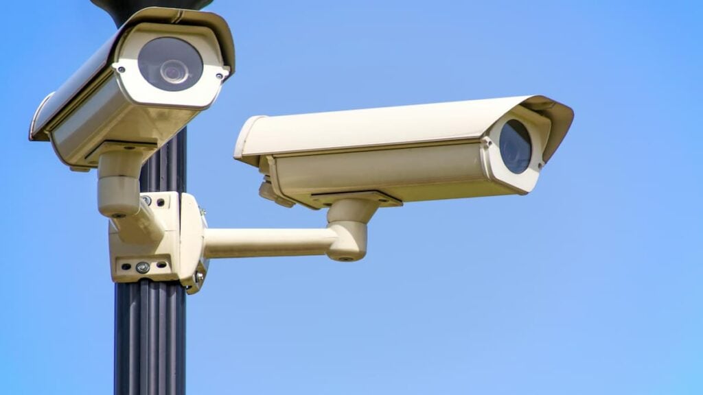 Texas Councilmember Melts Down After Surveillance Camera Ban, Suggests Ending Internet Access: ‘This Sounds Like a Childish Tantrum’ Close-up image of two outdoor surveillance cameras mounted on a pole