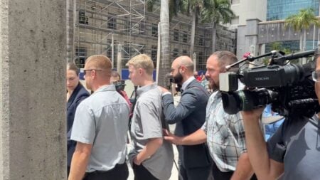 Timothy Hudson, 16, walks out of the James Lawrence King Federal Justice Building in Miami flanked by a public defender following a federal court hearing on May 27, 2026.
