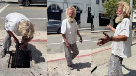 A disheveled man with dirty hands reaching into an open street storm drain in Hollywood, Los Angeles, California, appearing to fish.