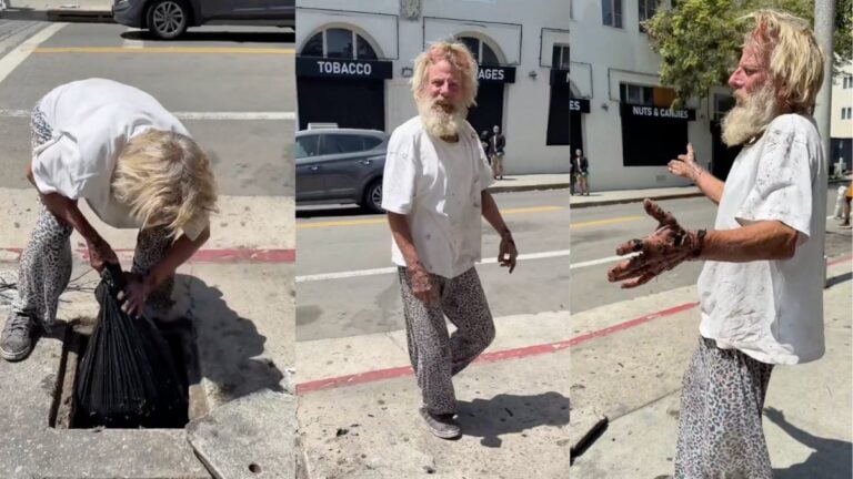 A disheveled man with dirty hands reaching into an open street storm drain in Hollywood, Los Angeles, California, appearing to fish.