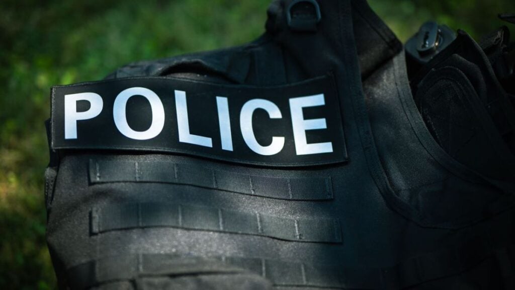 Illinois Woman Detained After Following Masked Man She Believed Was an ICE Agent: ‘Everyone Wears Masks Nowadays’ Detailed shot of a police vest lying outdoors, highlighting law enforcement gear.