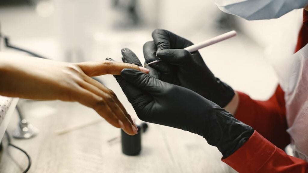 ‘This is just plain racism’: Maryland Woman Walks Into Asian-Owned Nail Salon To Call Out Black Customers Nail technician wearing black gloves applies nail treatment