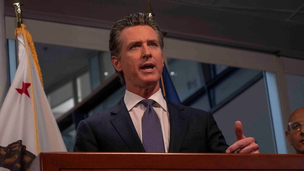 California Gov. Gavin Newsom Says DOJ Is Coming After Him and His Family: ‘Donald Trump Picked the Wrong Target’ Gavin Newsom speaking at a podium in Sacramento.