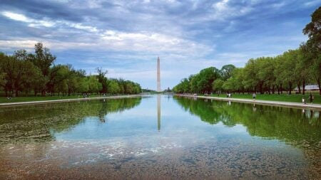 Photo of the Lincoln Memorial Reflecting Pool with The Washington Monument reflecting in the pool on a sunny day.