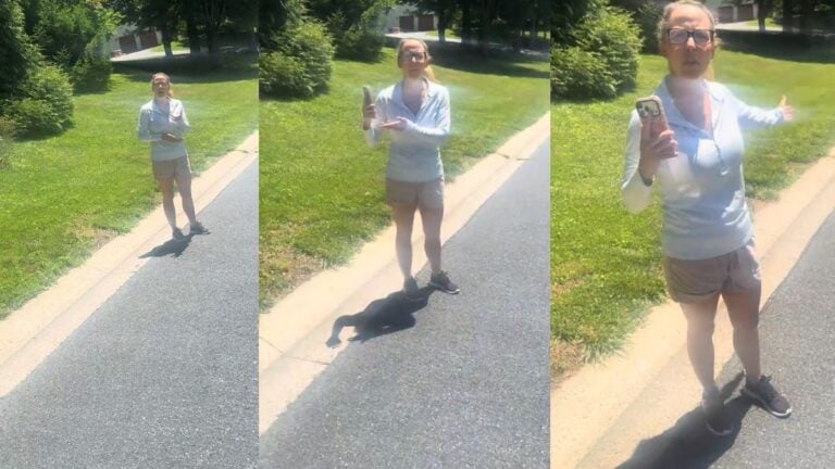 Woman standing in a residential street holding a cellphone