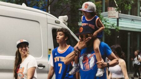 New York Woman Caught Dumping Garbage in Street So She Can Take Knicks-Themed Trash Can: ‘No Conscious Thought About Ethics’ A group of sports fans in vibrant team apparel enjoying a lively day in the city.