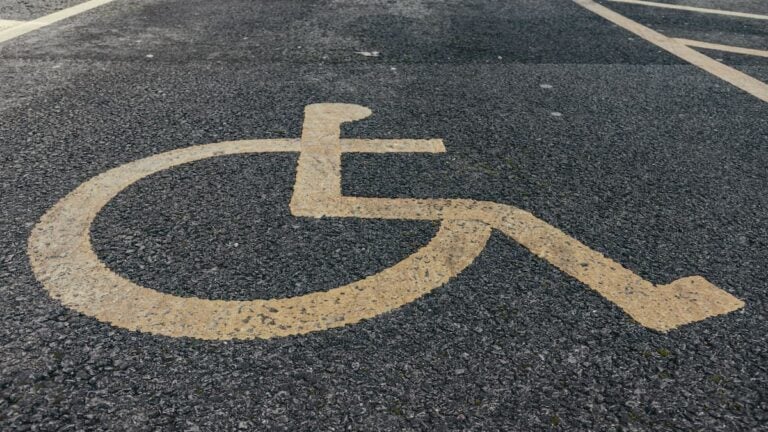 Accessible parking symbol painted on pavement.