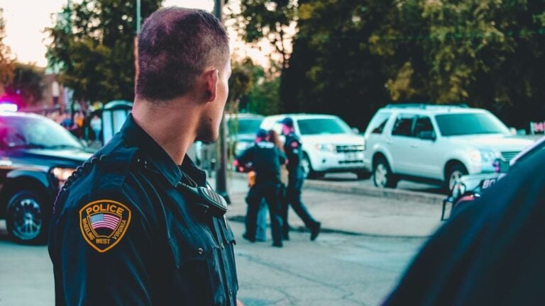 Police officer monitoring a street scene with patrol vehicles in Wheeling, WV.