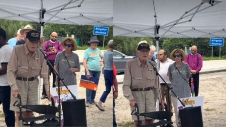 100-year-old WWII veteran Robert Hilliard speaks at a microphone outside a Florida detention facility during a vigil.