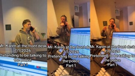 Man standing at a hotel front desk holding a phone to his ear