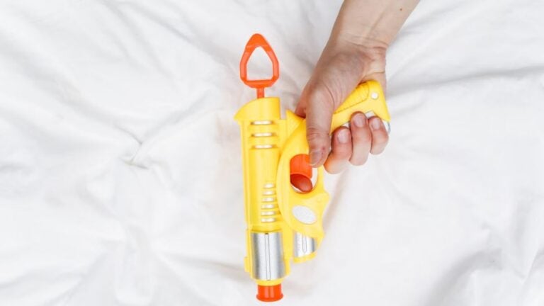 Texas Man, 34, Charged After Filming Himself Spraying Strangers With Water Blaster: ‘He Really Thought He Was Doing Something’ Bright yellow and orange water gun held by an adult hand.