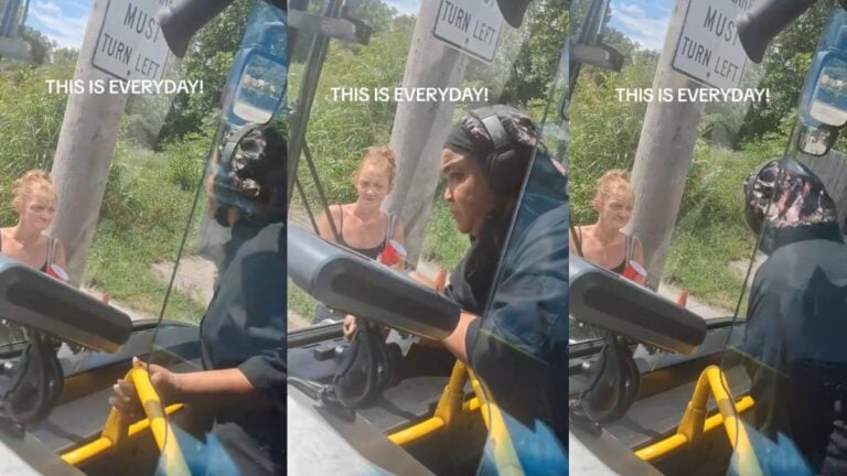 Passenger speaking to a woman standing outside a stopped city bus.
