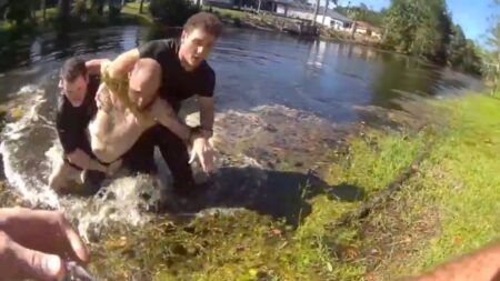 Florida Man Tries To Escape Deputies By Swimming Through Snake-And-Alligator-Infested Canal: ‘How Did He Not Get Bit?’ Body camera still of Flagler County deputies pulling a man from a Florida canal.