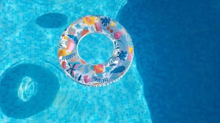 Georgia FedEx Driver Accidentally Falls Into Kiddie Pool, Pretends It Was Totally Planned: ‘I Needed That’ Vibrant inflatable swim ring floating in a sunlit pool, perfect for summer fun.