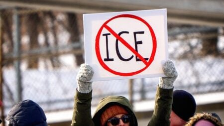 Backlash As Video Shows Oregon ICE Detaining Indigenous Young Woman on Public Sidewalk: ‘They Are Being Paid a Bounty Per Head’ Protesters hold signs in Golden Valley, Minnesota, on January 10, 2026, after the killing of Renee Good by a United States Immigration and Customs Enforcement (ICE) agent in Minneapolis.