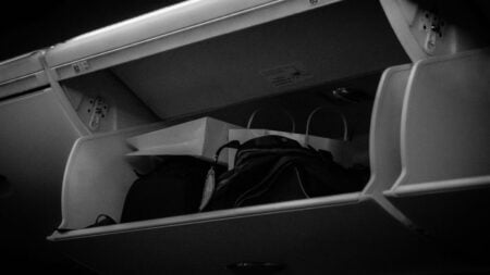 Airplane overhead bin with luggage inside