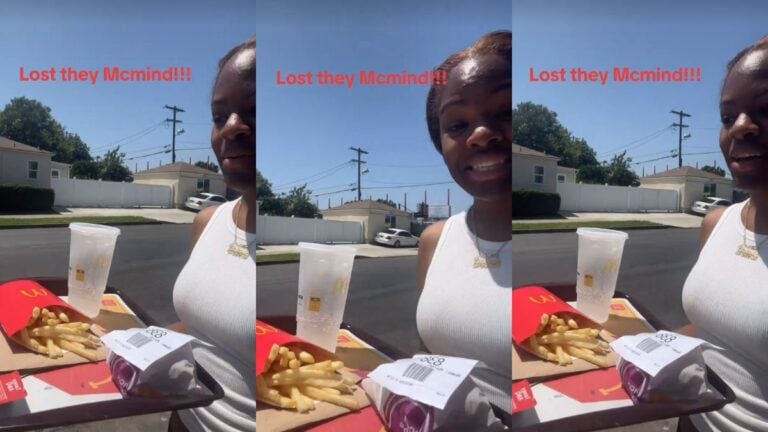 A woman walks outside carrying a McDonald's tray.