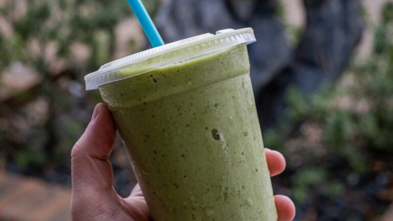 A person holding a green smoothie